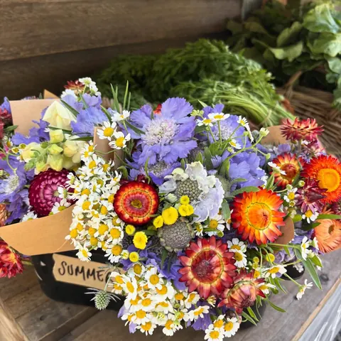 A crate of bright summer wildflowers at a market