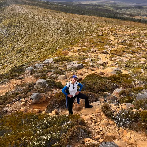 Liana hiking up a wild, scrubby hillside